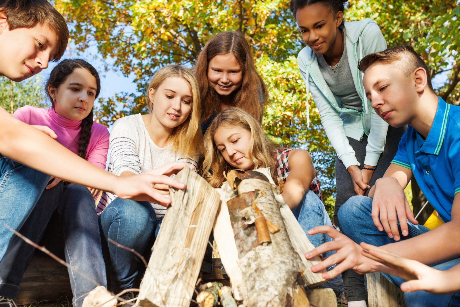 Jugendliche-stapeln-Holz-fuer-ein-Feuer