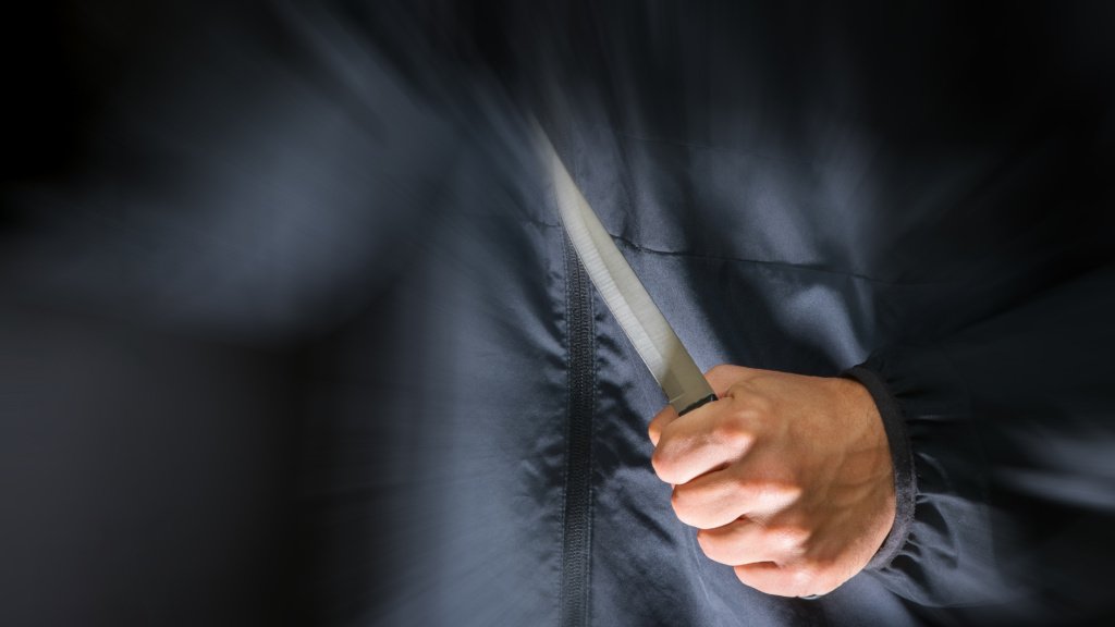 Street robber with a knife - killer person with sharp knife about to commit a homicide, murder scenery
