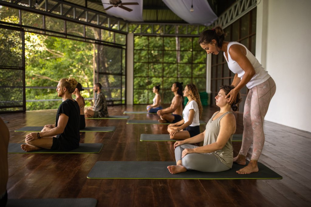 Female yoga teacher leading an yoga class